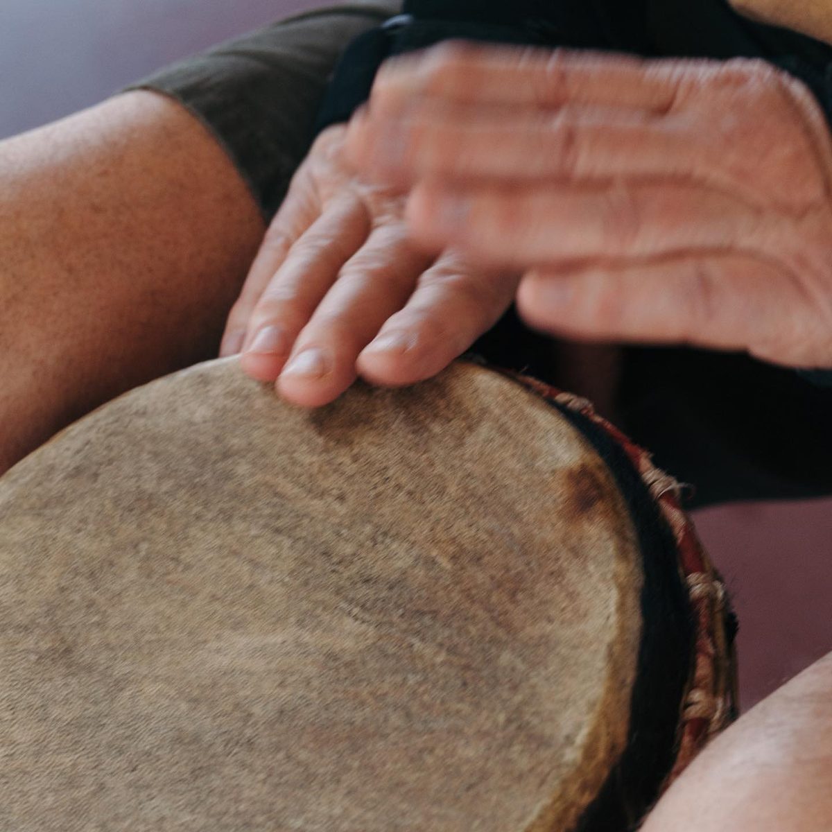 Close-up of hands playing a djembe drum