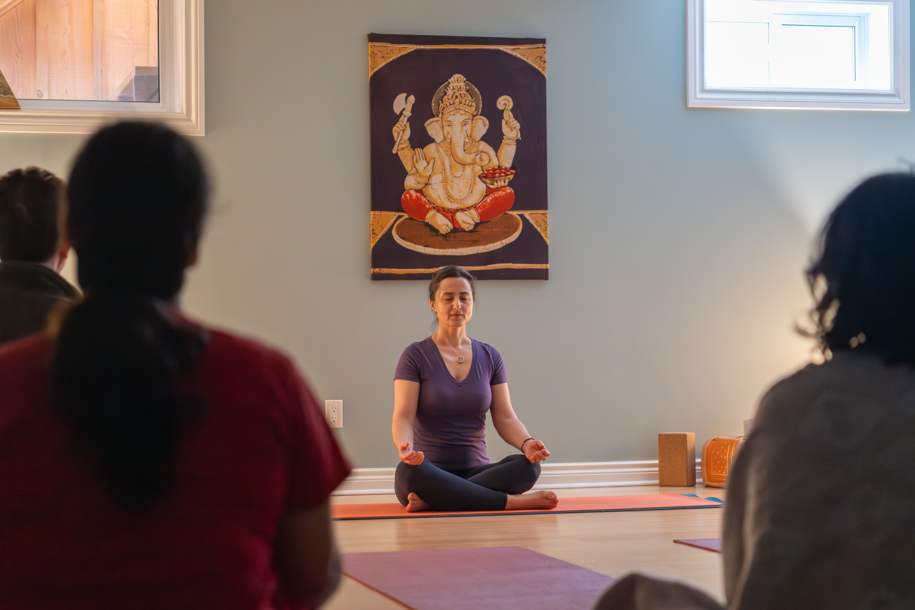 Zofia seated in meditation in front of a Ganesh tapestry